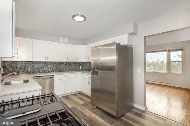 kitchen with tasteful backsplash, sink, appliances with stainless steel finishes, and dark wood-type flooring