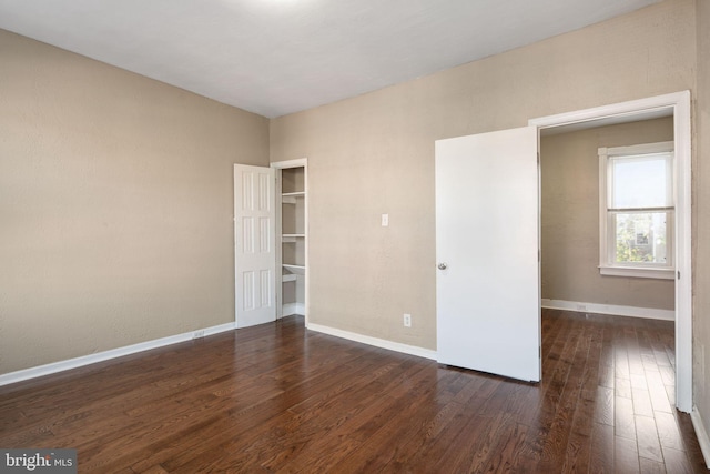 unfurnished room with dark hardwood / wood-style flooring