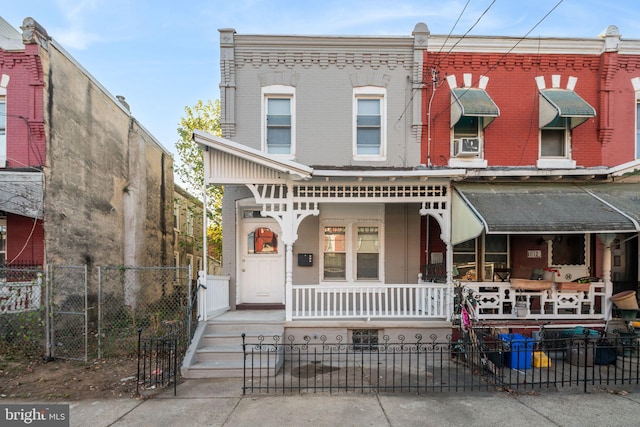 townhome / multi-family property featuring a porch and cooling unit