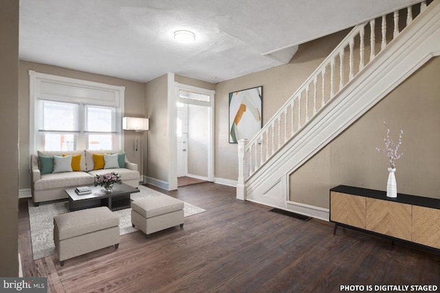 living room with dark hardwood / wood-style flooring and a textured ceiling