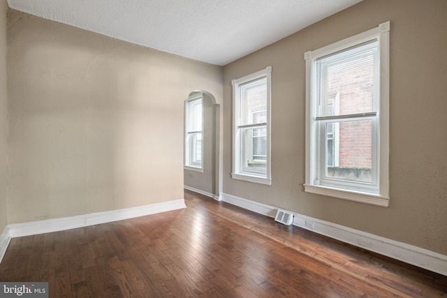 spare room with dark wood-type flooring and a textured ceiling