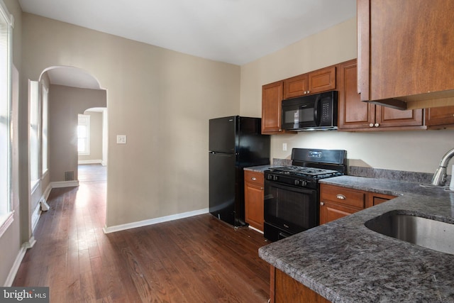 kitchen with sink, dark hardwood / wood-style flooring, and black appliances