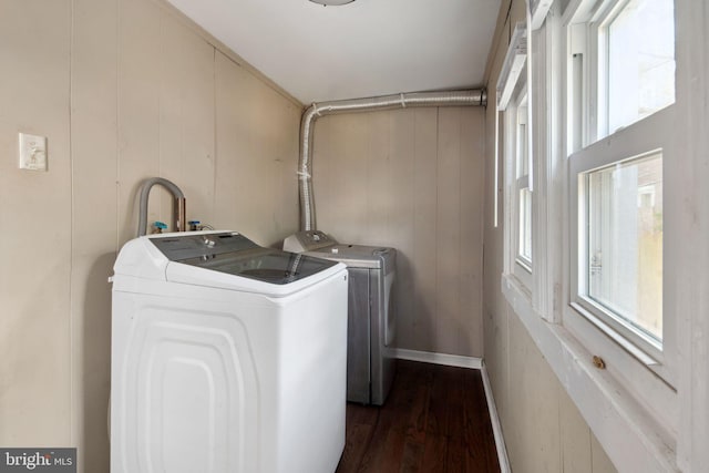 laundry room featuring dark hardwood / wood-style floors, wood walls, and independent washer and dryer