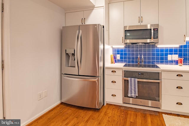 423 18th St NE Unit 4, Washington, DC 20002 - kitchen with stainless steel appliances, light wood-type flooring, light countertops, and white cabinetry