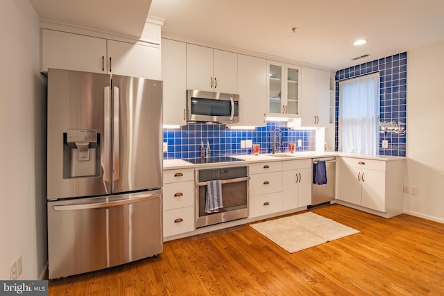 423 18th St NE Unit 4, Washington, DC 20002 - kitchen with stainless steel appliances, light countertops, light wood-style floors, white cabinetry, and tasteful backsplash