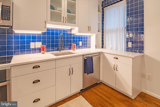 423 18th St NE Unit 4, Washington, DC 20002 - kitchen with appliances with stainless steel finishes, a sink, light wood-style flooring, and tasteful backsplash