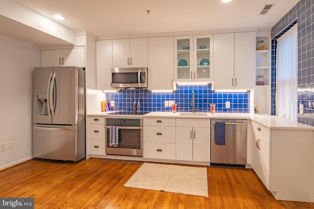 423 18th St NE Unit 4, Washington, DC 20002 - kitchen with stainless steel appliances, a sink, open shelves, light countertops, and recessed lighting