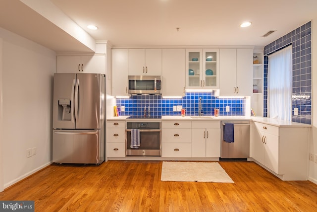 423 18th St NE Unit 4, Washington, DC 20002 - kitchen featuring stainless steel appliances, a sink, light countertops, light wood finished floors, and recessed lighting