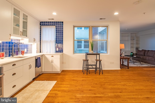 kitchen with white cabinetry, sink, light hardwood / wood-style floors, and appliances with stainless steel finishes