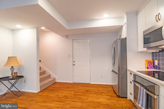 kitchen featuring white cabinets, stainless steel appliances, and light hardwood / wood-style floors