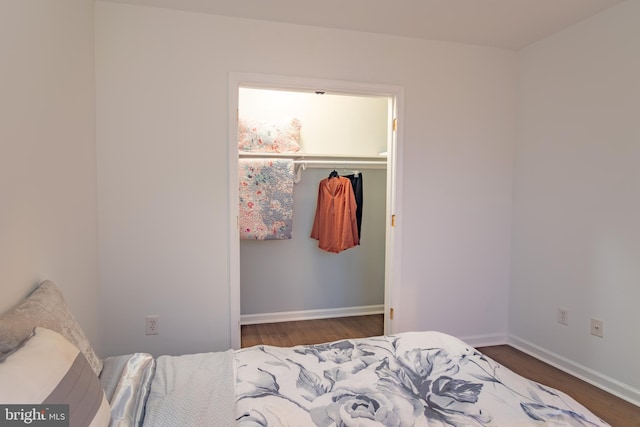 bedroom with dark hardwood / wood-style flooring and a closet