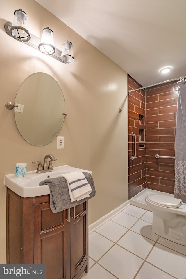 bathroom featuring toilet, a tile shower, vanity, and tile patterned floors