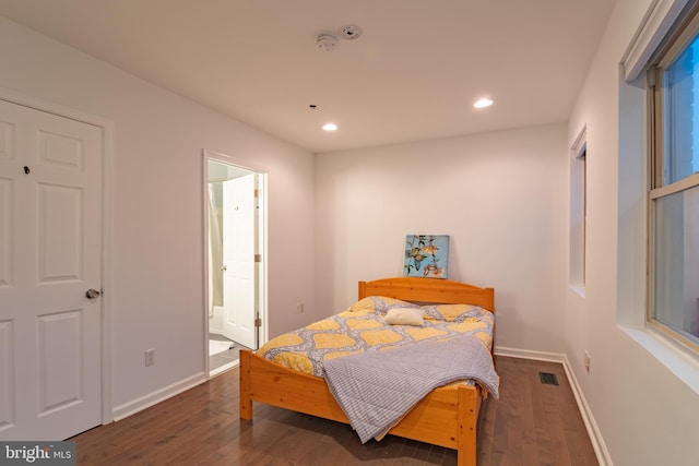 bedroom featuring dark hardwood / wood-style floors and ensuite bath