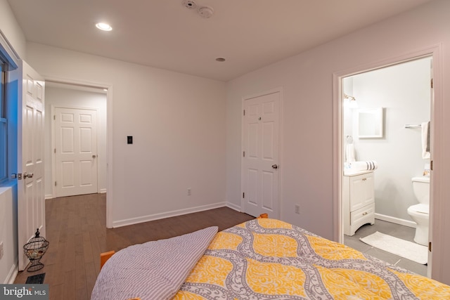 bedroom featuring connected bathroom and dark hardwood / wood-style flooring