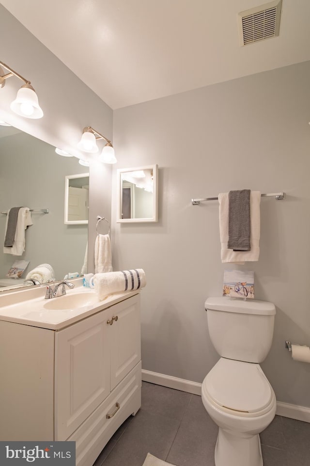 bathroom with tile patterned flooring, vanity, and toilet