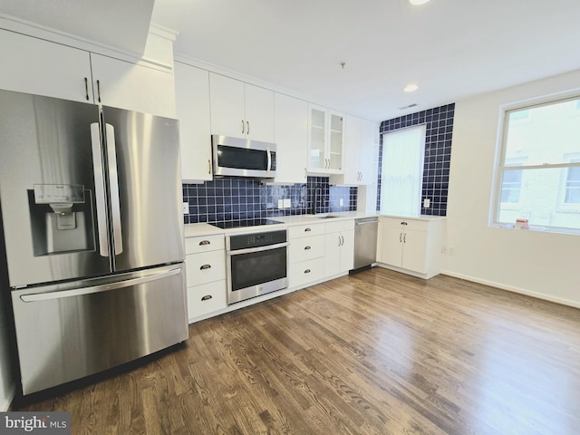 kitchen featuring backsplash, white cabinetry, stainless steel appliances, and dark wood-type flooring