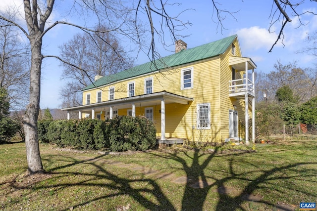 exterior space with a balcony and a front lawn