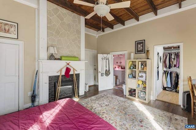 bedroom with beam ceiling, a high end fireplace, wood ceiling, and dark hardwood / wood-style floors