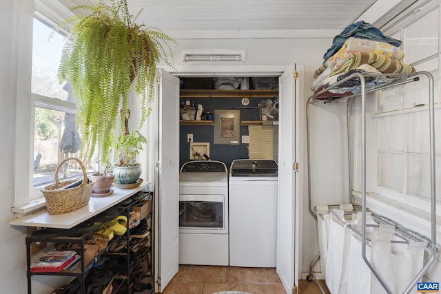 clothes washing area featuring tile patterned floors, washer and clothes dryer, and a healthy amount of sunlight