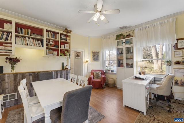 dining room featuring hardwood / wood-style floors, plenty of natural light, ceiling fan, and crown molding