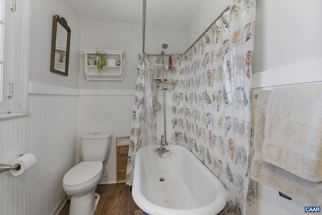 bathroom featuring hardwood / wood-style floors, shower / bath combination with curtain, and toilet