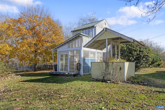 view of property exterior featuring a lawn and a sunroom