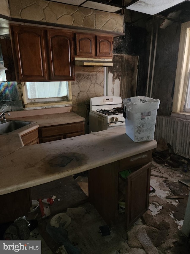 kitchen with dark brown cabinets, white range with gas stovetop, and sink