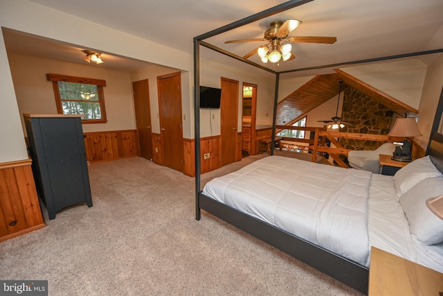 bedroom with carpet, wooden walls, and ceiling fan