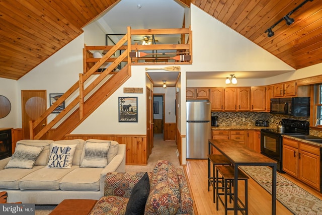 kitchen featuring rail lighting, wooden walls, black appliances, high vaulted ceiling, and wooden ceiling