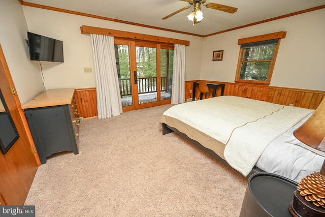 bedroom with ceiling fan, wood walls, carpet floors, and access to outside