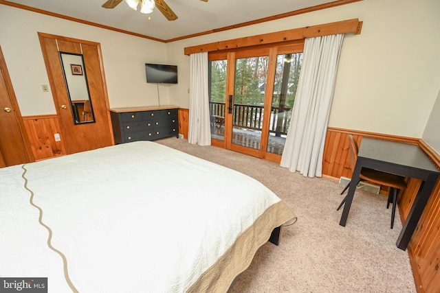 bedroom with carpet flooring, access to exterior, ceiling fan, and wood walls