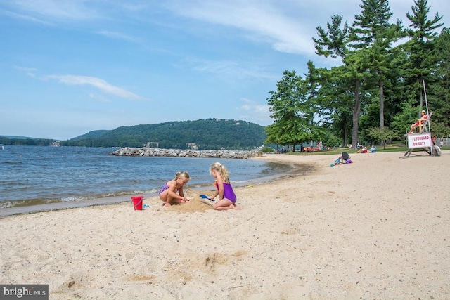 water view with a mountain view and a view of the beach