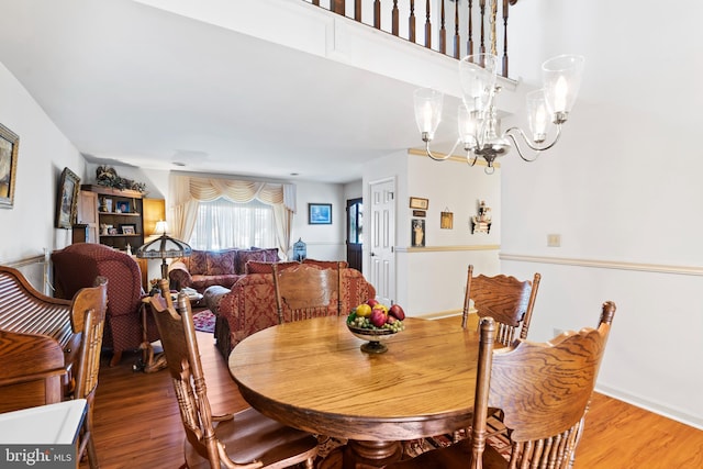 dining space with hardwood / wood-style floors and an inviting chandelier