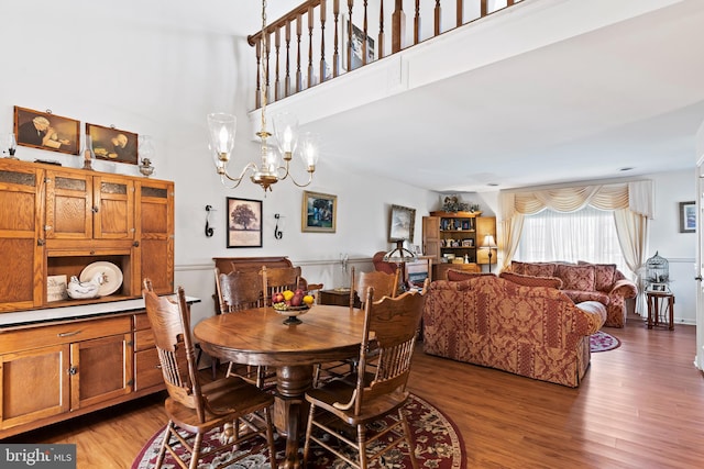 dining space with hardwood / wood-style floors and an inviting chandelier