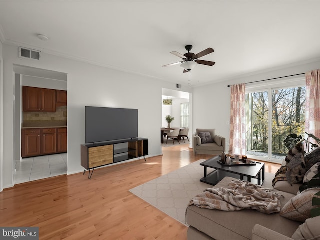 living room with ceiling fan, light hardwood / wood-style flooring, and ornamental molding