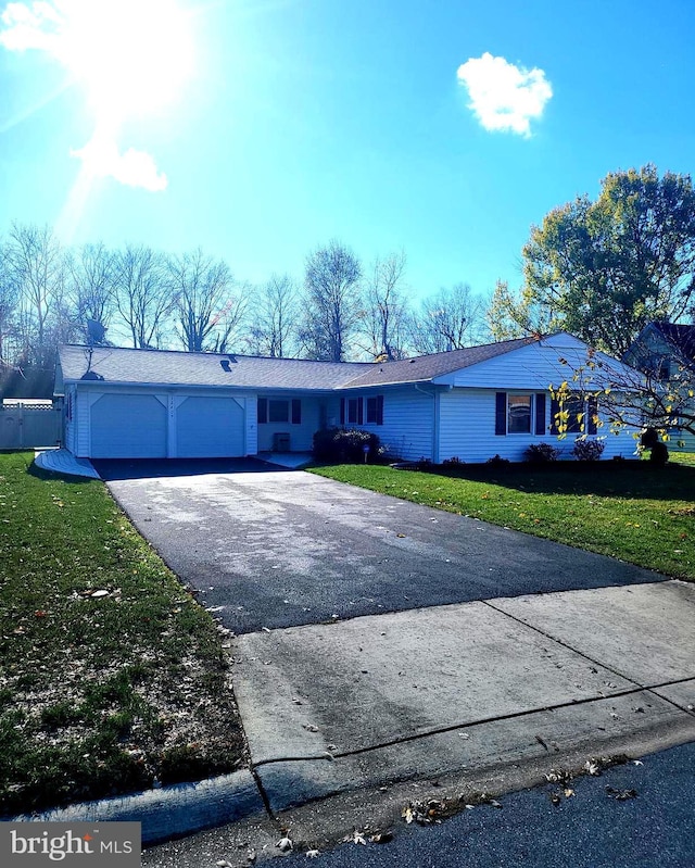 view of front facade featuring driveway, an attached garage, and a front lawn