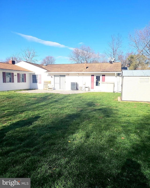 rear view of property with a lawn, cooling unit, and stucco siding