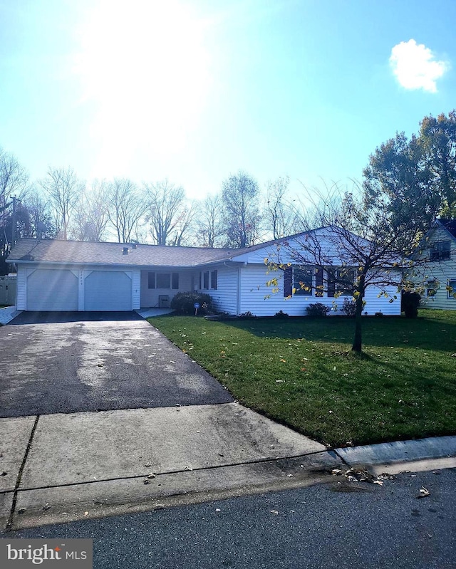 ranch-style home with driveway, a front lawn, and an attached garage