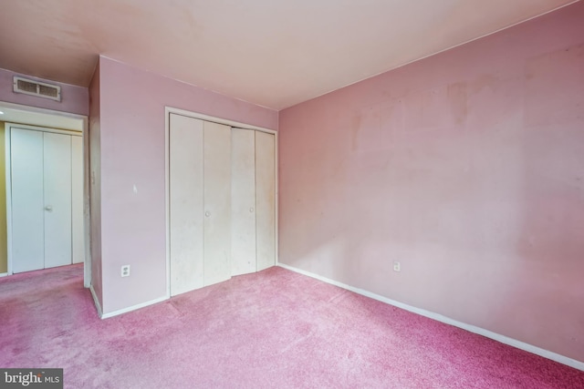 unfurnished bedroom featuring light colored carpet and a closet