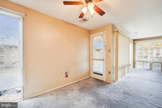 carpeted spare room featuring ceiling fan