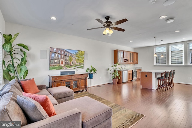 living room featuring ceiling fan and dark hardwood / wood-style flooring