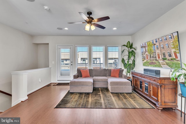 living room with dark hardwood / wood-style flooring and ceiling fan