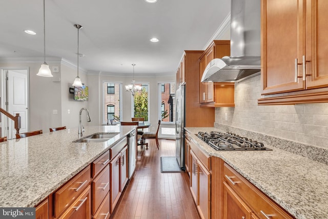 kitchen with wall chimney range hood, sink, ornamental molding, dark hardwood / wood-style flooring, and stainless steel appliances