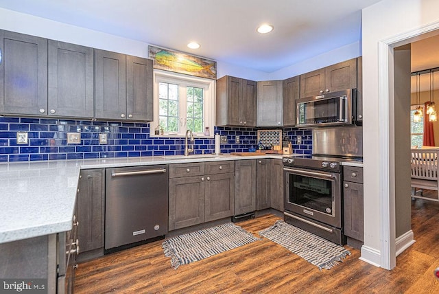 kitchen featuring dark hardwood / wood-style flooring, stainless steel appliances, plenty of natural light, and sink