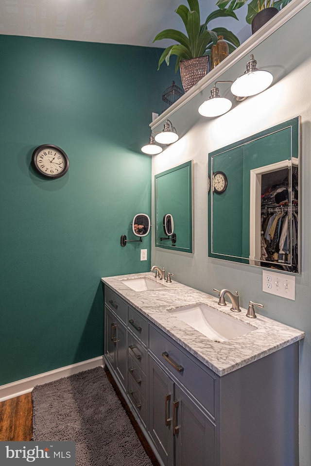 bathroom with hardwood / wood-style flooring, vanity, and vaulted ceiling