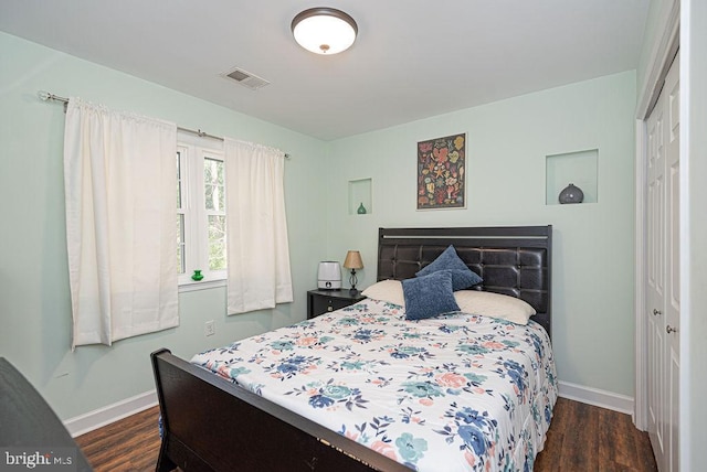 bedroom with a closet and dark hardwood / wood-style flooring