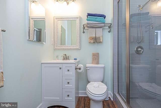 bathroom with vanity, wood-type flooring, an enclosed shower, and toilet