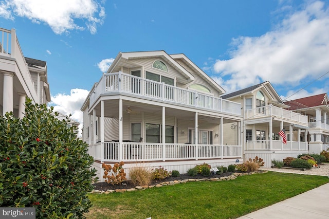 view of front facade featuring a front yard and a balcony