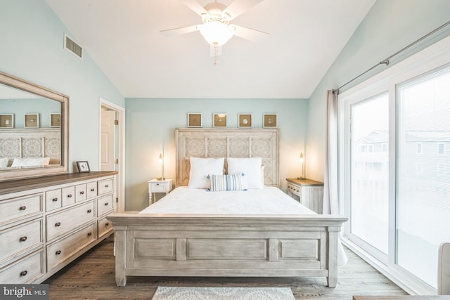 bedroom featuring access to exterior, dark hardwood / wood-style flooring, and vaulted ceiling