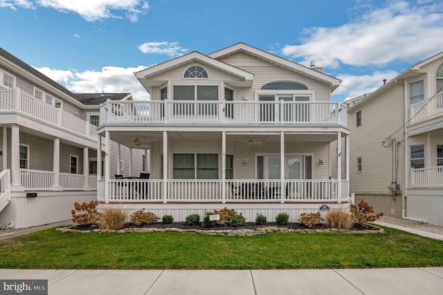 view of front of home with a balcony and a front lawn